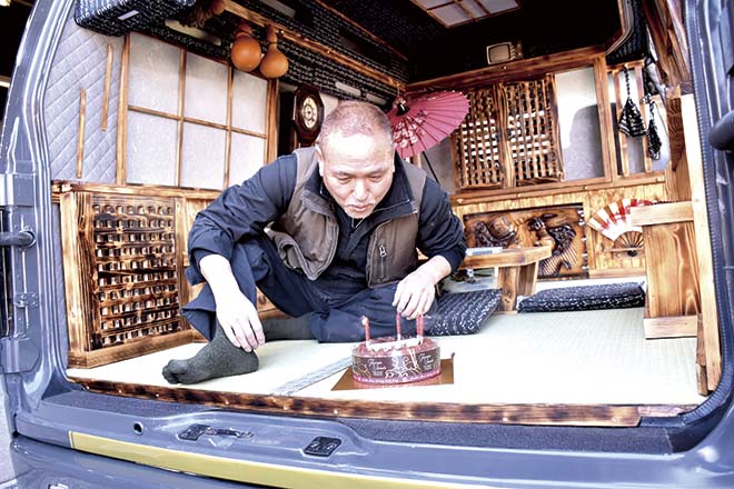 社長がケーキのろうそくを消している様子
